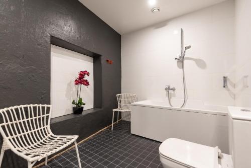 a bathroom with a tub and a toilet and a sink at Stylish apartment with parking in Telliskivi in Tallinn