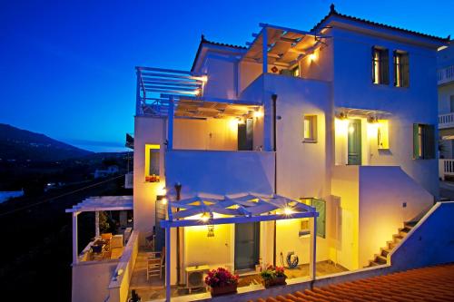 a white house with lights on it at night at Anemomiloi Studios in Andros