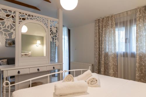 een slaapkamer met een wit bed en een spiegel bij Villa La Varik 2 in Litóchoron