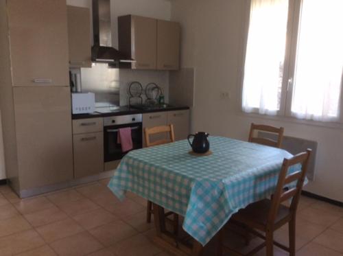 une cuisine avec une table et une cuisine avec une table et des chaises dans l'établissement F1 spacieux, à Hérépian