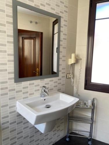 a bathroom with a white sink and a mirror at Hotel Los Molinos in Llanes