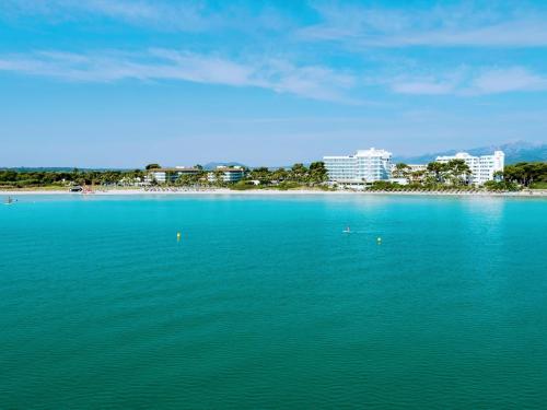 a large body of water with a beach and buildings at Playa Esperanza Resort Affiliated by Meliá in Playa de Muro