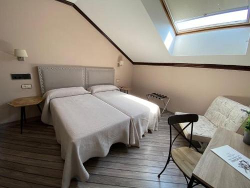 a bedroom with a large white bed and a window at Hotel Los Molinos in Llanes