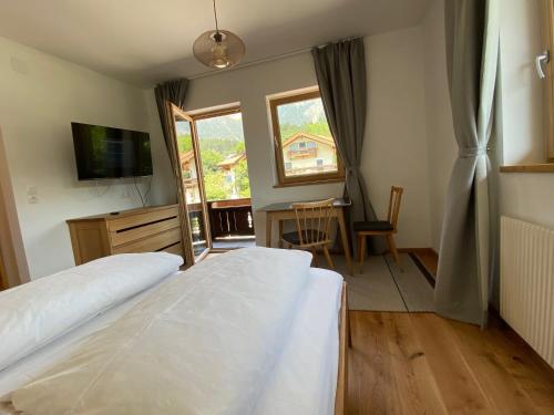 a bedroom with a bed and a desk and a television at Waldruh in Wiesing