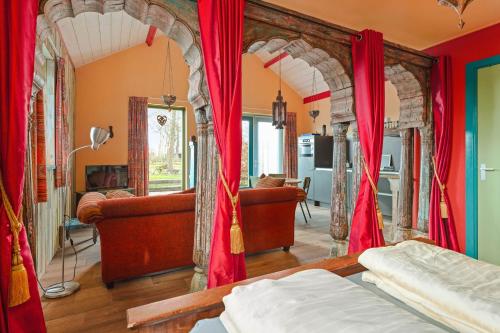 a bedroom with red drapes and a room with a bed at Vakantiewoning 1001 Nacht in Welsum