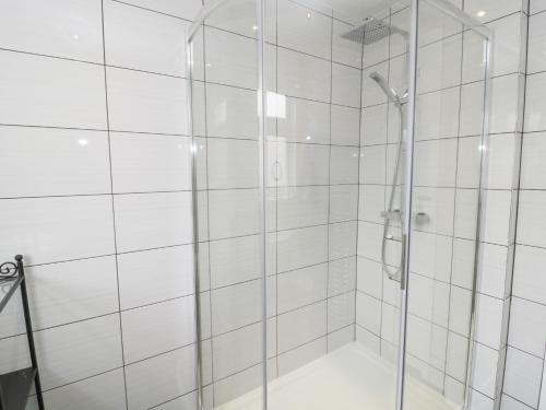a shower with a glass door in a bathroom at Sandy Toes Cottage in Newbiggin-by-the-Sea