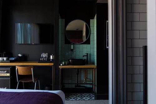 uma casa de banho com um lavatório e um espelho na parede em The Baltic Hotel em Liverpool