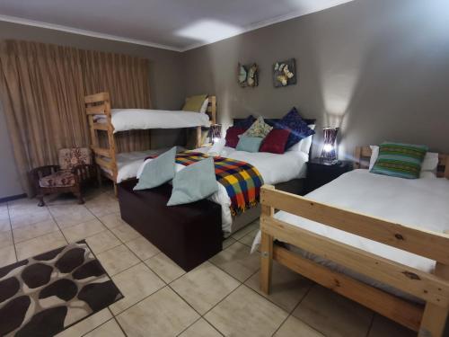 a bedroom with two bunk beds and a couch at Harties Honeymoon suite Mountain side - Hartbeespoort dam in Hartbeespoort