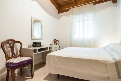 a bedroom with a bed and a chair and a mirror at Vivilo Collection - Chalet Mare - Private parking - Just 50 meters from the beach in Sperlonga