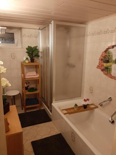 een badkamer met een bad en een douche bij Ferienhaus Rosemarie Erlbach Vogtland in Erlbach