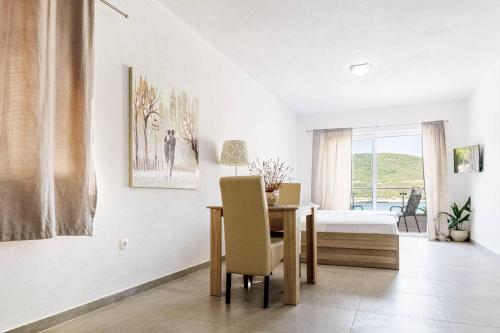 a dining room with a table and a bedroom at Apartmani Divna in Neum