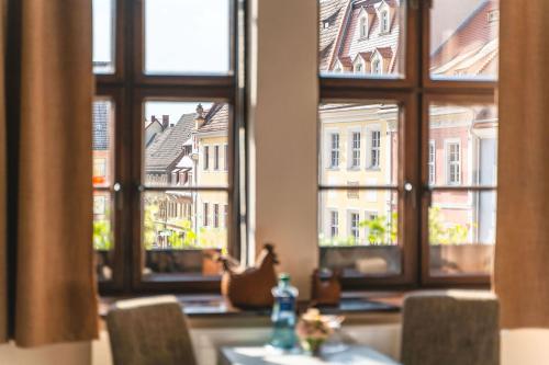 a table with chairs in front of a window at Pirnscher Hof - Hotel Garni in Pirna