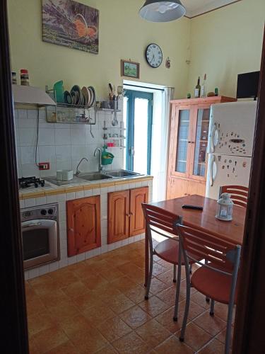 a kitchen with a table and a sink and a refrigerator at La Torre di Barbara in Ardea