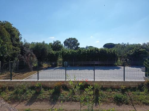 a tennis court behind a fence at La Torre di Barbara in Ardea