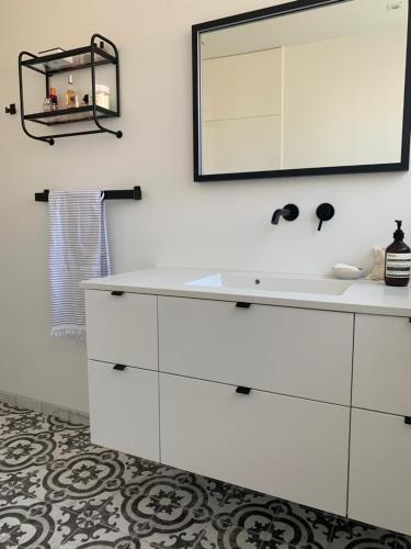 a bathroom with a white sink and a mirror at Renovated villa with private garden in Rungsted