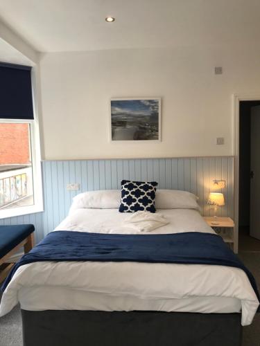 a bedroom with a large bed with a blue blanket at The Wellington House Hotel in Blackpool