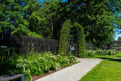 a garden with a wooden fence and a walkway at 12 Jabłek - ośrodek wypoczynkowy na Mazurach in Nidzica