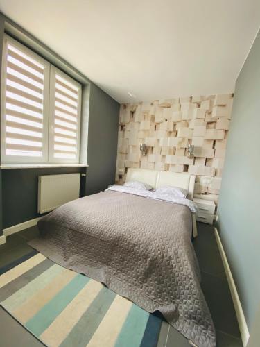 a bedroom with a large bed in a room with a window at D&M Apart Lipowa 12 in Białystok