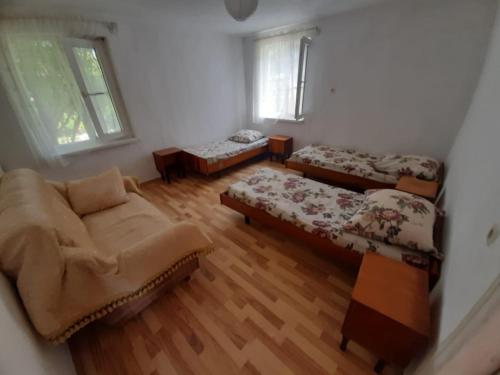 a living room with two beds and a couch at Гостевой дом проезд братьев Джинджолия 22 in Novy Afon