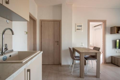 cocina con mesa, sillas y fregadero en Minimalist apartments w/ view (by Powerbnb), en Tesalónica