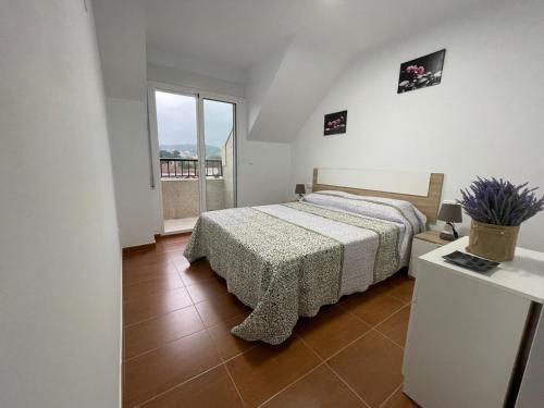 una camera con un letto e una grande finestra di Altamira a Caldas de Reis