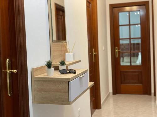 a bathroom with a counter with a mirror and a door at Altamira in Caldas de Reis