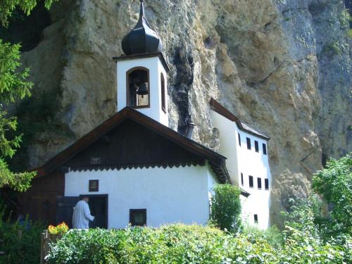 a man standing in front of a church next to a mountain at Haus Hartl in Saalfelden am Steinernen Meer