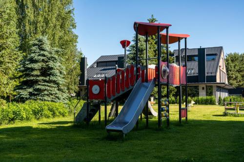 a playground with a slide in the grass at 12 Jabłek - ośrodek wypoczynkowy na Mazurach in Nidzica
