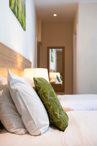 a bed with green pillows on it at The Limes Country Lodge Hotel & Admiral Restaurant in Solihull
