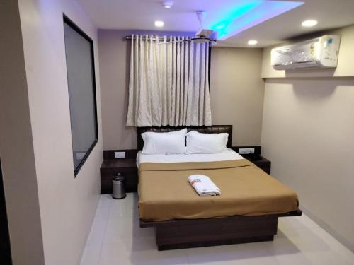 a small bedroom with a bed in a room at Sun Inn Residency in Mumbai