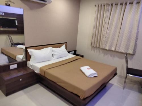 a bedroom with a bed with a towel on it at Sun Inn Residency in Mumbai