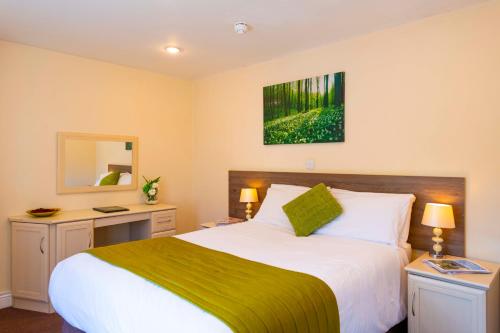 a bedroom with a large bed and a mirror at The Limes Country Lodge Hotel & Admiral Restaurant in Solihull