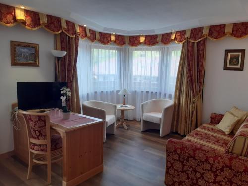 a living room with a couch and a table and chairs at Garni Franca b&b in Selva di Val Gardena