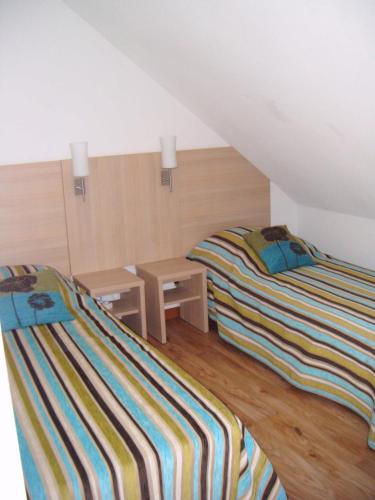 um quarto com 2 camas e uma mesa no sótão em Les jardins Ramel em Luchon