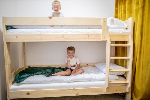 zwei Kinder auf Etagenbetten in der Unterkunft Miodowe Apartamenty in Miejsce