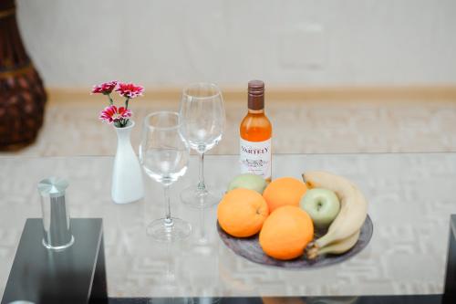 a bowl of fruit on a table with wine glasses at TipTop Hotel CITY CENTER in Chişinău