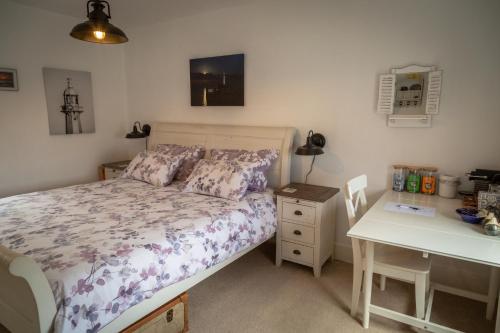 a bedroom with a bed and a table and a desk at Stone's throw Cottage Mevagissey in Mevagissey