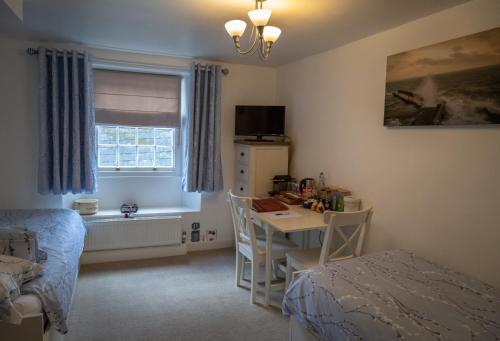 a bedroom with a desk and a bed and a table at Stone's throw Cottage Mevagissey in Mevagissey