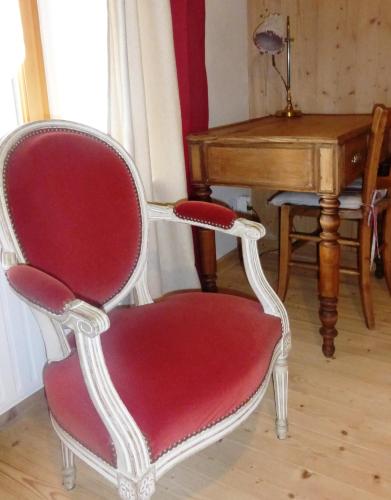 a red chair sitting in front of a piano at Chambres d'hôtes Béred Vuillemin in Baume-les-Dames