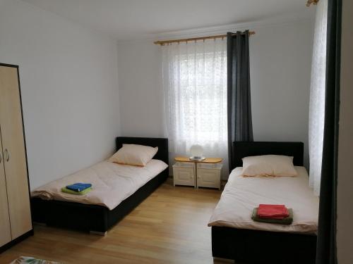 a bedroom with two beds and a window at Zielony Zakątek in Krynki