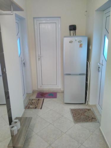 a kitchen with a white refrigerator in a room at Къща за гости Синьо Лято in Pomorie