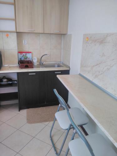 a kitchen with two chairs and a sink and a counter at Къща за гости Синьо Лято in Pomorie