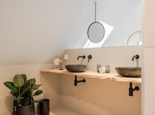 een badkamer met 2 wastafels en een spiegel bij 99 Lifestyle Suite in Zwaag