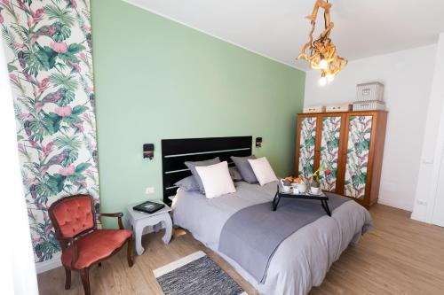 a bedroom with a bed and a chair and a chandelier at Maison Madeleine Rome in Rome