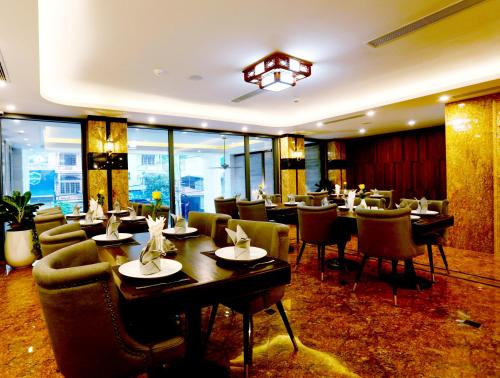 a restaurant with tables and chairs in a room at Silk River Hotel Ha Giang in Ha Giang