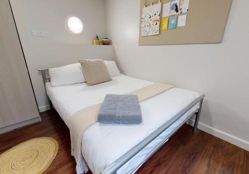 a small bedroom with a bed with white sheets and pillows at Tufnell House in London in London