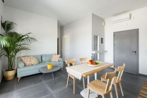 - un salon avec un canapé bleu et une table dans l'établissement Yuka Villas Collection, à Nea Iraklitsa