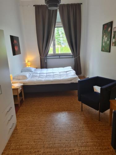 a bed in a room with a window and a couch at Dalasjö vandrarhem in Vilhelmina