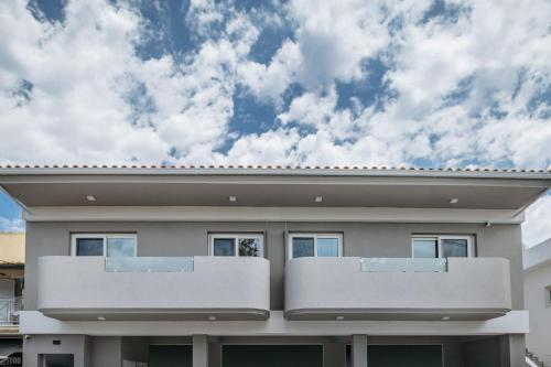 una casa con un cielo azul en el fondo en Corner45 Apartments, en Kalamaki