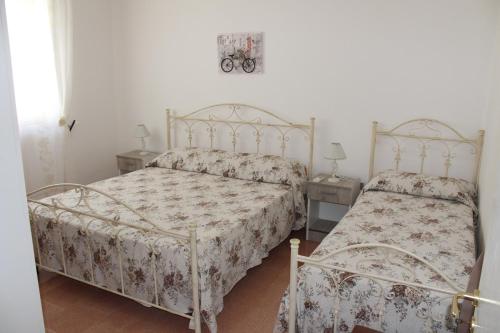トッレ・サン・ジョヴァンニ・ウジェントにあるmare verde salentoのベッドルーム1室(ベッド2台、テーブル2台付)